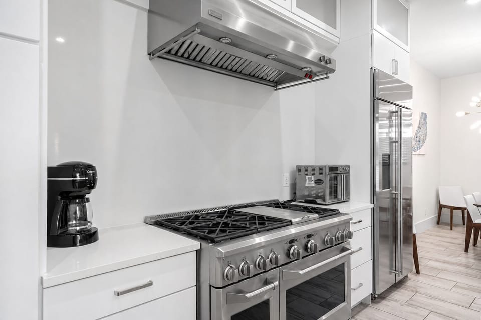 2nd Floor - Kitchen detail highlights the six-burner gas range, commercial-style hood, double ovens, and abundant preparation space for large-group meals.