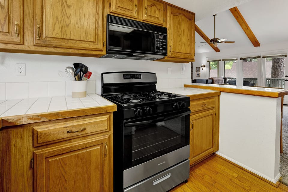 Fully equipped kitchen with plenty of storage, stove, fridge, Keurig coffee maker - perfect for meal prep after a fun day on the mountain or the golf course