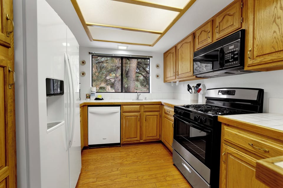 Fully equipped kitchen with plenty of storage, stove, fridge, Keurig coffee maker - perfect for meal prep after a fun day on the mountain or the golf course
