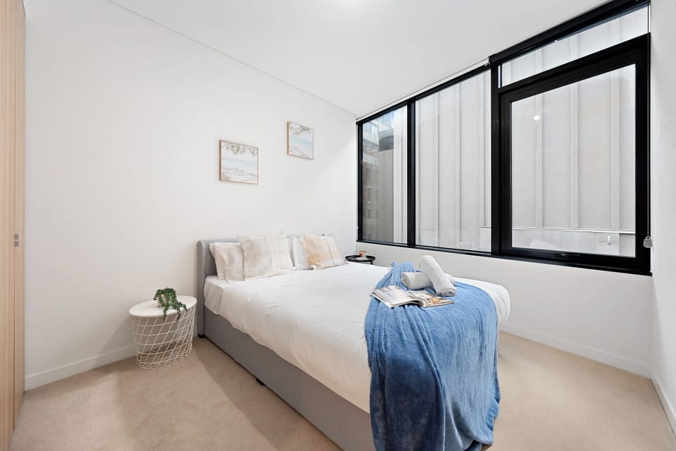 Bright modern bedroom with large windows and a cozy, calming design
