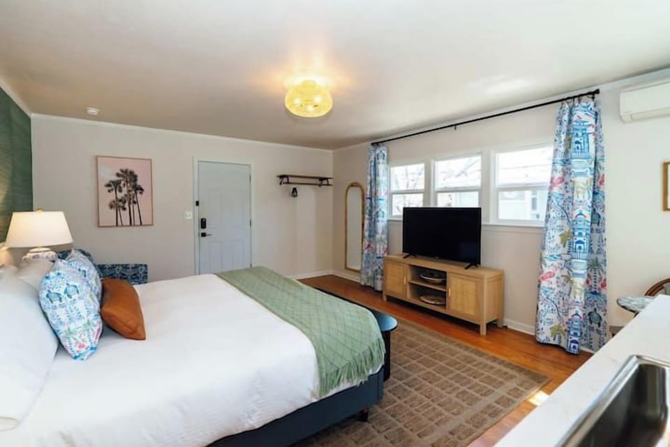 Swank 5: Bright open-plan suite offering a plush king bed and TV entertainment area.