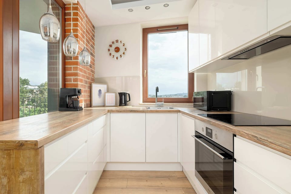 Modern open-plan kitchenette equipped with essential appliances, sleek cabinetry, ample countertop space, and everything needed for preparing meals.