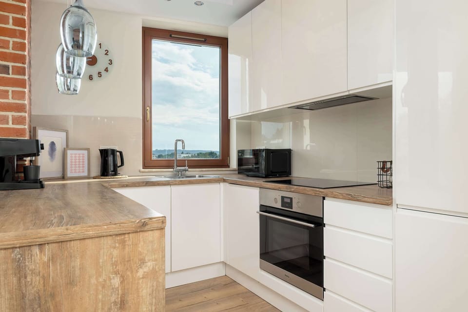 Modern open-plan kitchenette equipped with essential appliances, sleek cabinetry, ample countertop space, and everything needed for preparing meals.