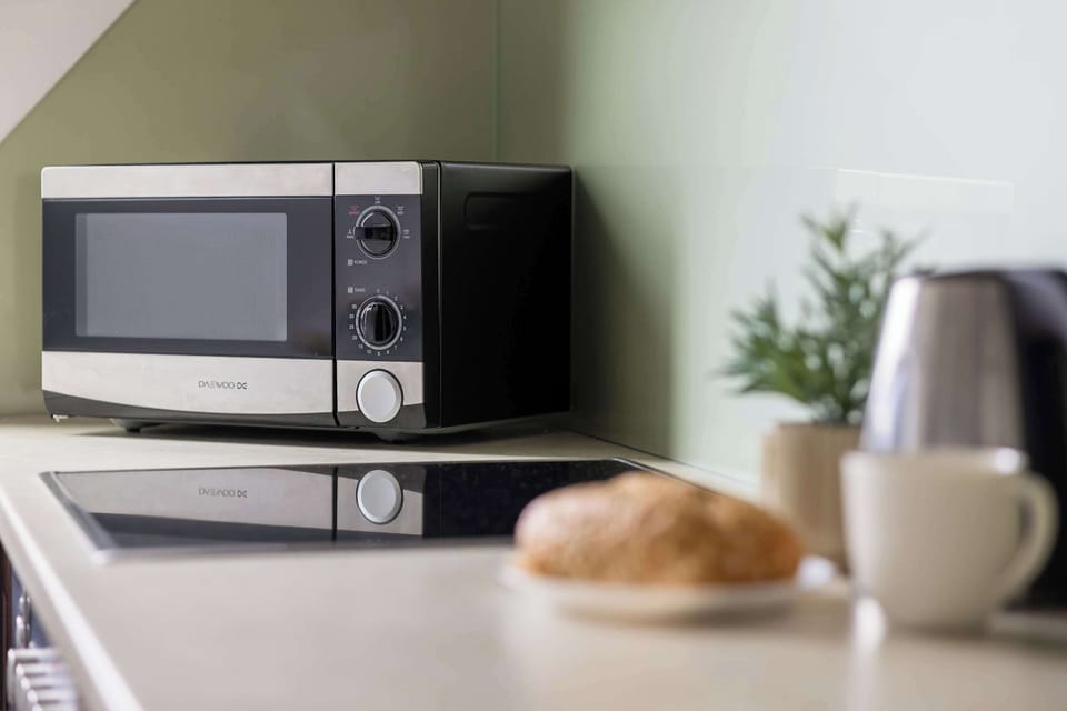 Kitchenette detail with a microwave, kettle, and breakfast setup.