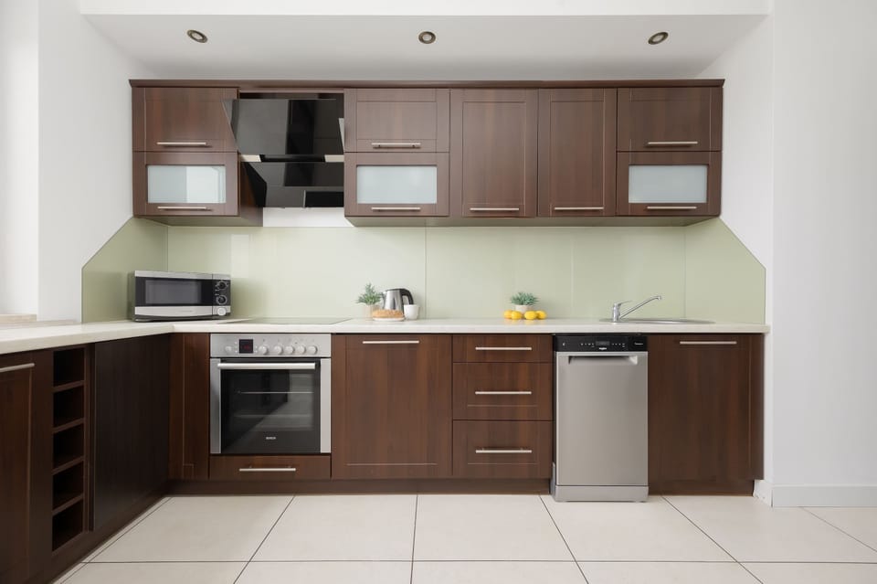 Modern kitchenette with built-in appliances and ample cabinet space.