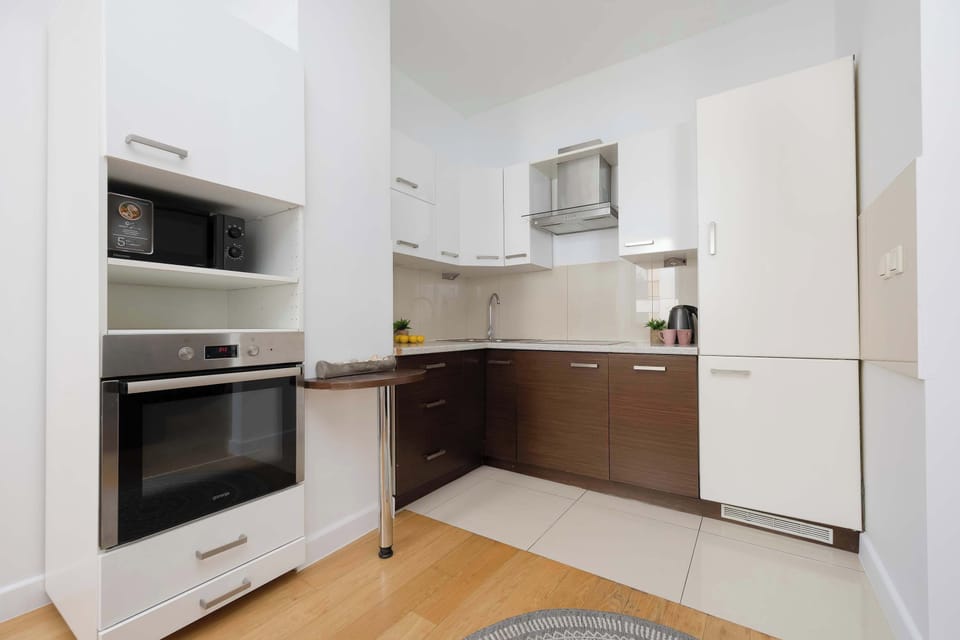 Fully equipped modern kitchenette with built-in appliances, ample storage, and a practical layout.