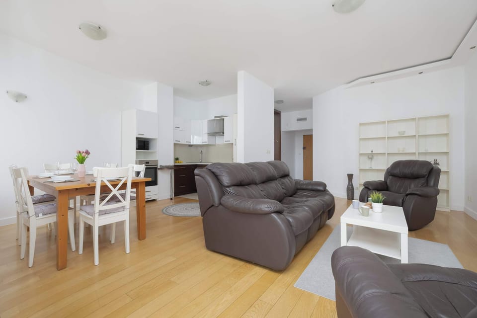 Open-plan living area combining comfortable seating, a dining space, and a modern kitchenette.