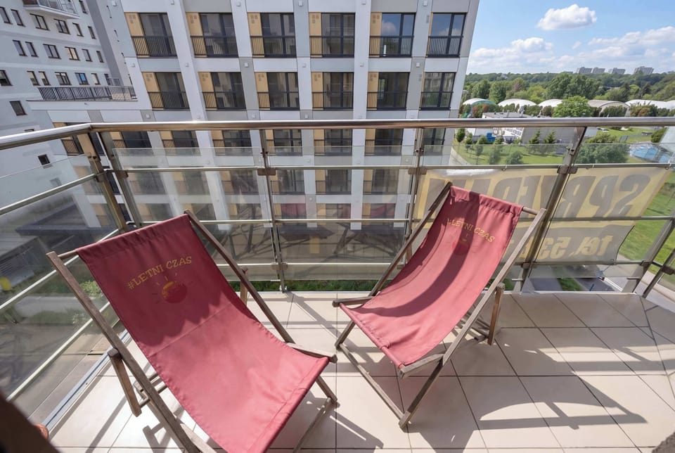 Sunny balcony with comfortable lounge chairs, creating a relaxing outdoor space with views of the surrounding neighborhood.