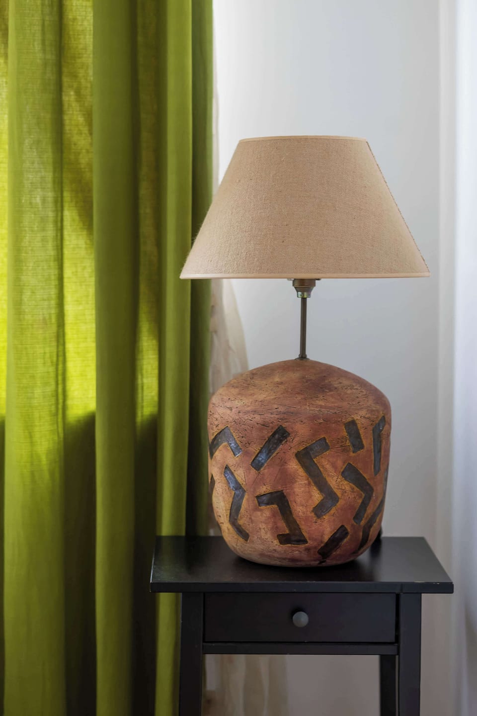 Close-up of the bedside table with a stylish lamp, adding a warm and elegant touch to the bedroom.