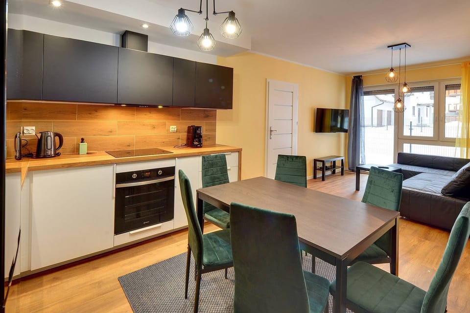 The living area features a sleek coffee table and a flat-screen television.