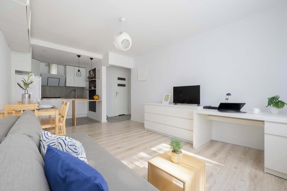 Comfortable lounge area with sofa, coffee table, TV, and bright interior.