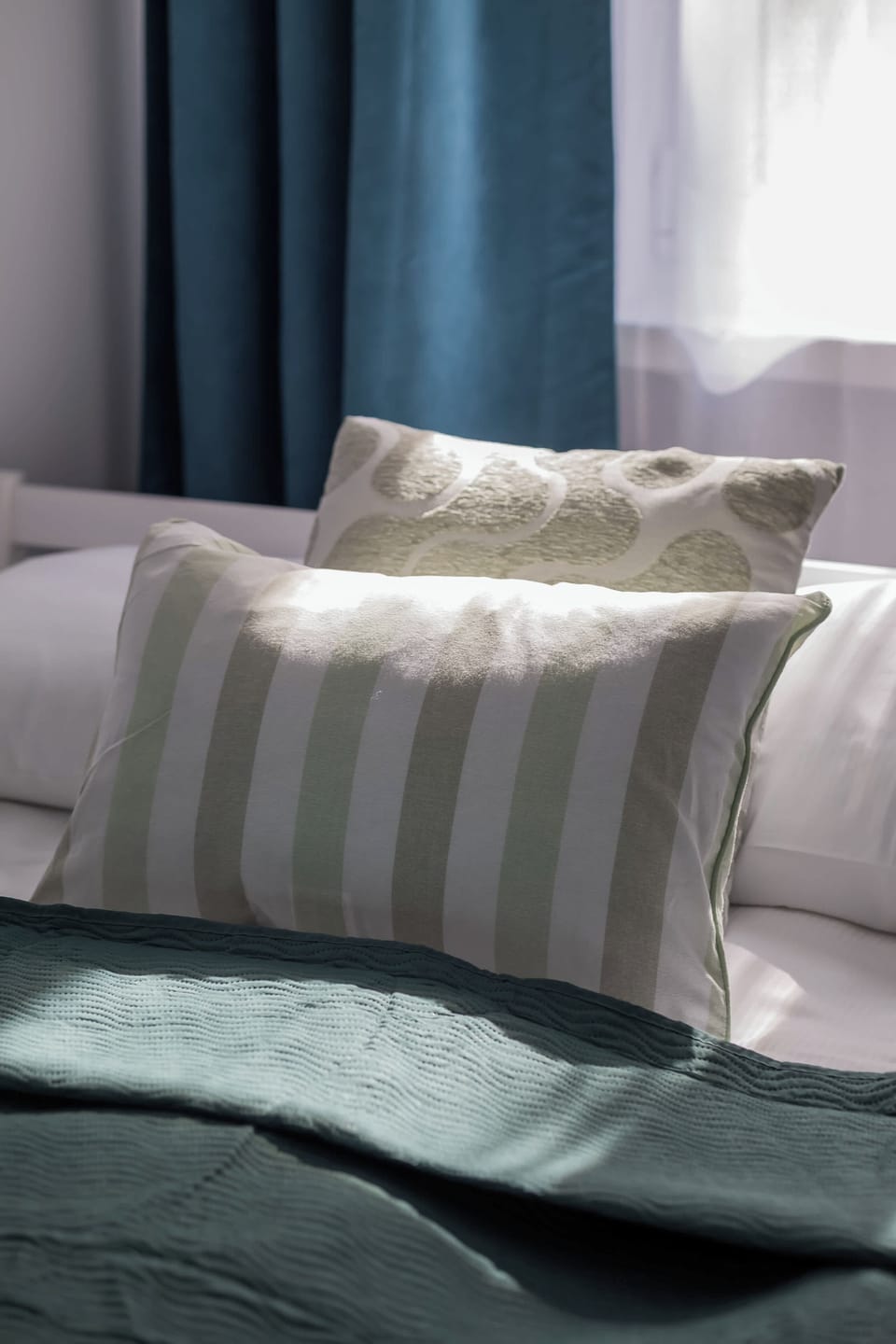Comfortable double bed with soft bedding, decorative cushions, and elegant finishing touches.