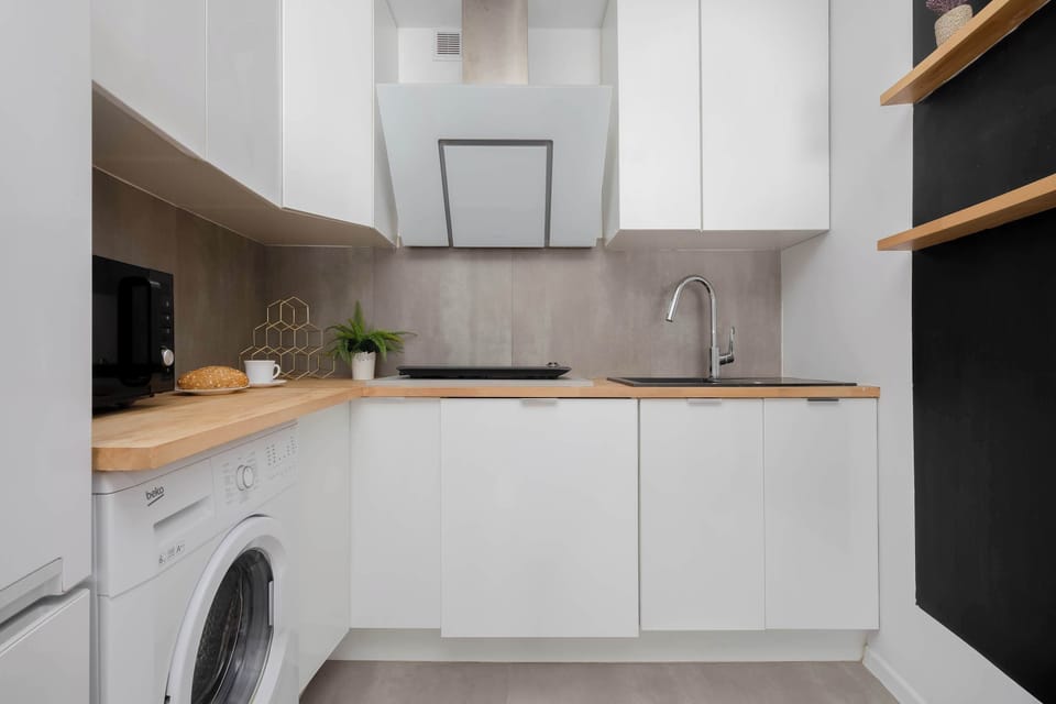 Well-equipped open-plan kitchenette with wooden worktops, built-in appliances, and ample storage.