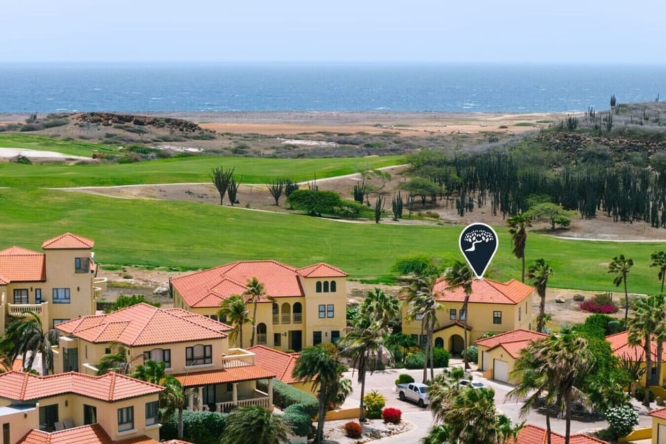 Prime resort position situated alongside lush green fairways, framed by dramatic desert hills and sweeping ocean views.