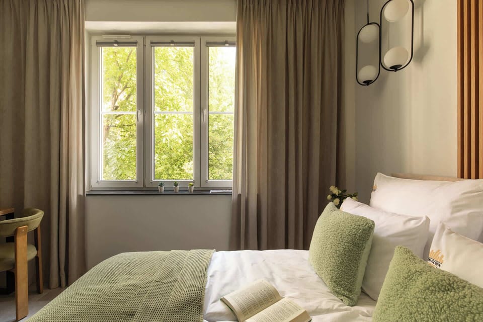 Przestrzeń apartamentu łączy funkcję sypialni i części wypoczynkowej. Znajduje się w niej wygodne łóżko małżeńskie z hotelową pościelą i kompletem poduszek oraz telewizor Smart TV z dostępem do kanałów satelitarnych. 