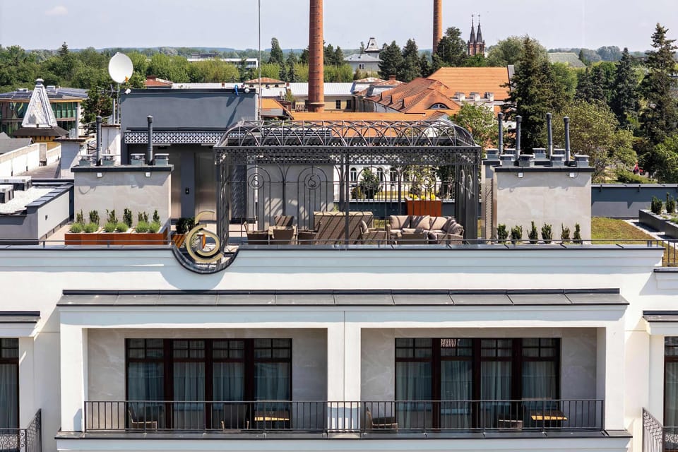 A rooftop terrace with tables and chairs overlooking the neighborhood. It offers a pleasant place to relax.