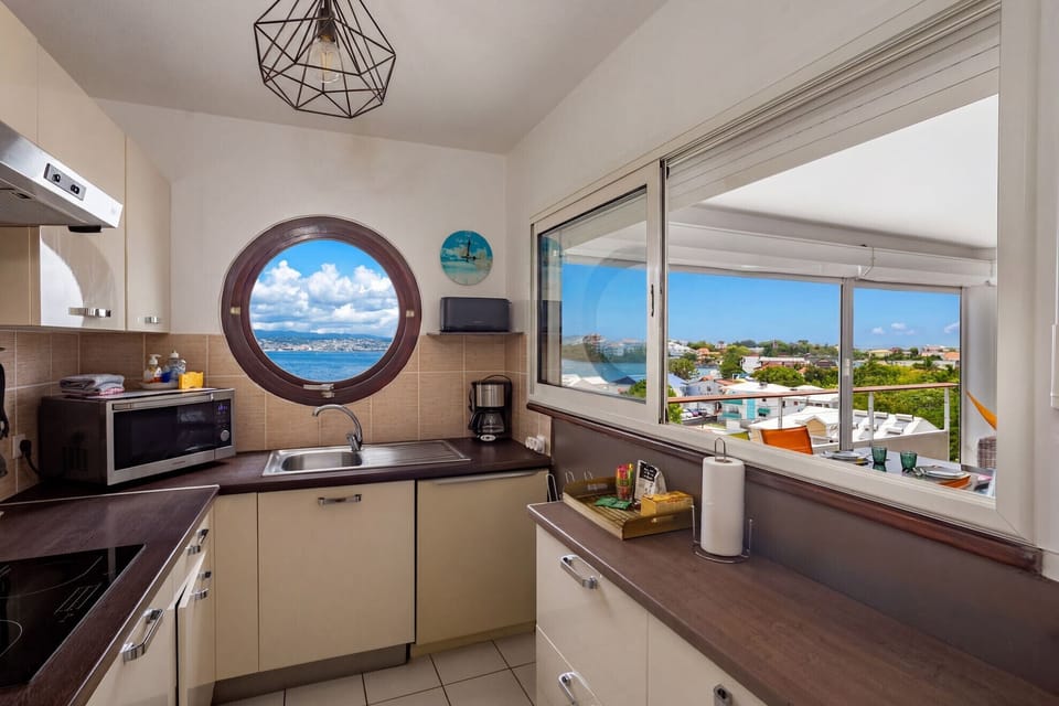 Modern, fully equipped kitchen at Ti'Bato Apartment overlooking Fort-de-France Bay and the Caribbean Sea.