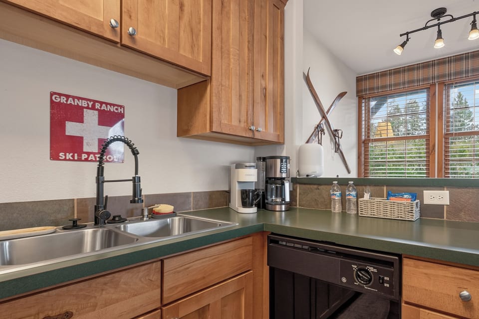 Your kitchen is ready for mountain mornings with everything you need to brew fresh coffee and prepare meals. Notice the crossed vintage skis on the wall—a charming nod to the slopes nearby.