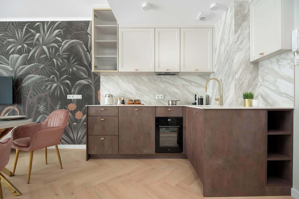 A compact kitchenette offers modern appliances and plenty of storage space. The design is clean and functional.