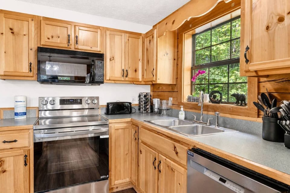 Fully stocked kitchen with stainless appliances & forest views 🍳
