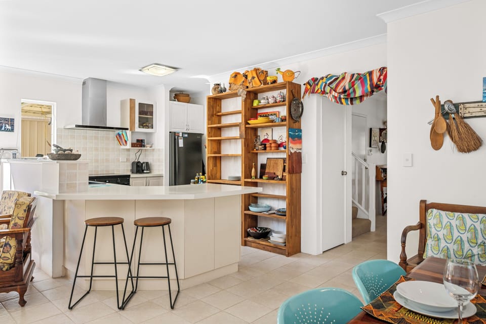 Gather for casual meals or enjoy a morning coffee at the breakfast bar in this bright, open-plan kitchen and dining space.