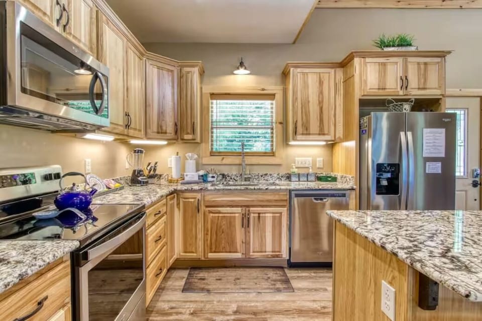 Bright rustic kitchen with granite counters and stainless steel appliances