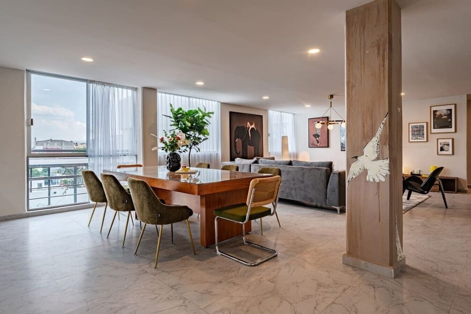 Spacious open-concept dining and living area with city views.