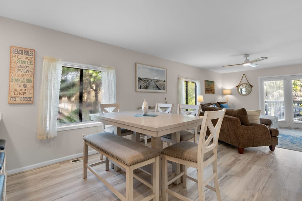 Bright dining area with counter-height table seating six and open living room beyond, Ocean Bliss Unit 102, Surfside Beach