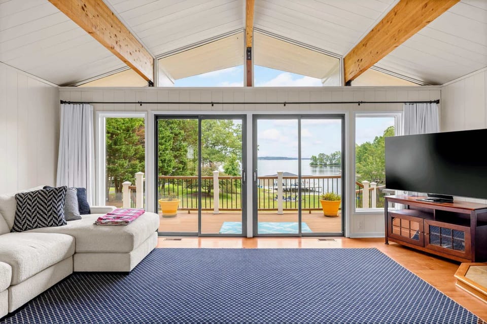 Great Room - Vaulted cedar beams and a wall of glass pull the lake inside, keeping the whole group together.