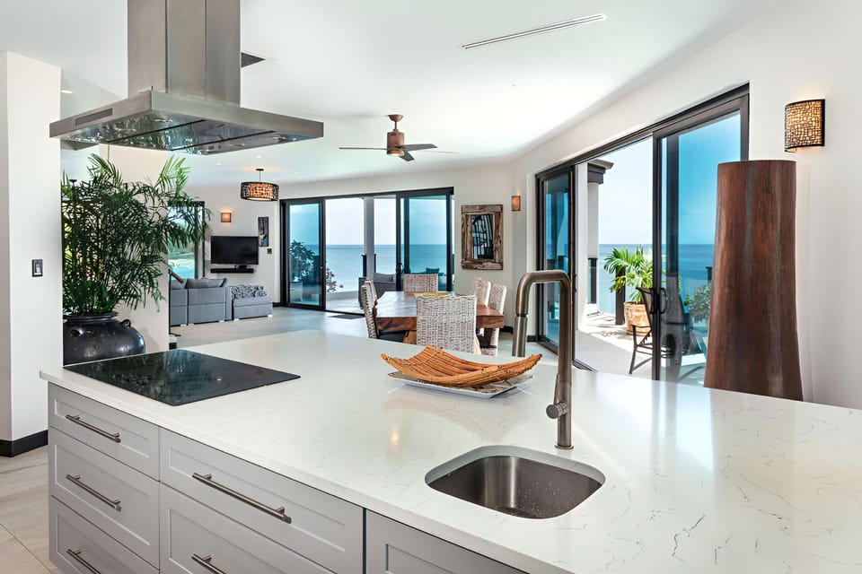 Gather at the island and toast sunsets beyond the glass.