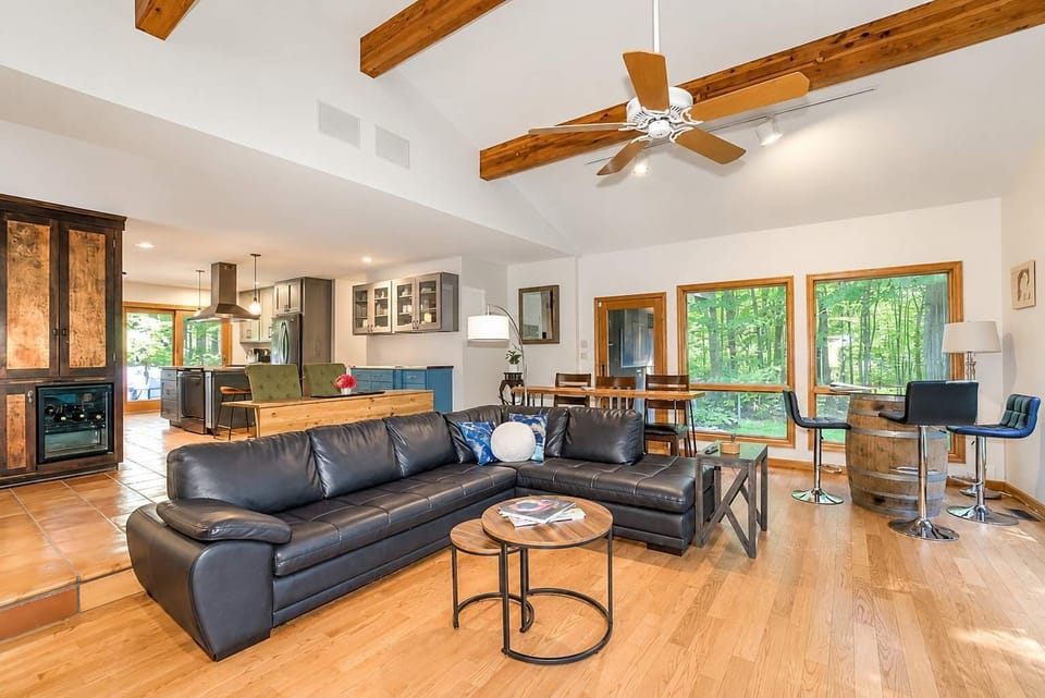 Open living room with a stone fireplace and seamless flow into the kitchen