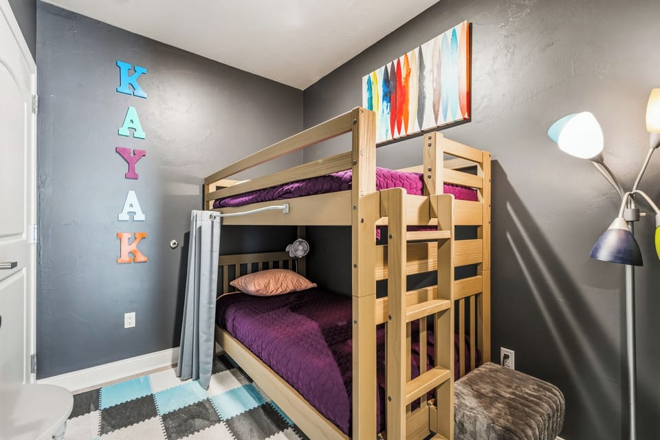 The den-style bunk room gives younger guests or friends a cozy space of their own. A twin-over-twin bunk bed makes bedtime comfortable while preserving plenty of room throughout the condo.