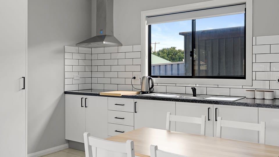 Modern fully equipped kitchen with full-size appliances and ample bench space.