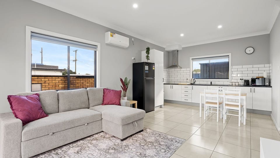 Spacious living area with comfortable seating, smart TV and plenty of natural light.