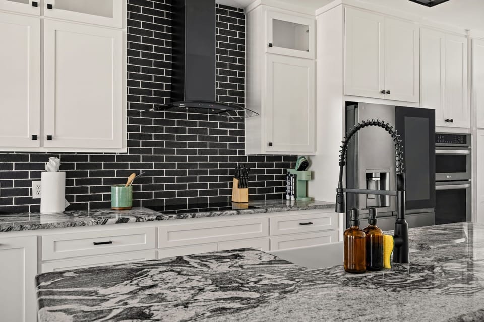 Stylish kitchen featuring elegant granite countertops, a modern tile backsplash, and thoughtful finishes throughout.