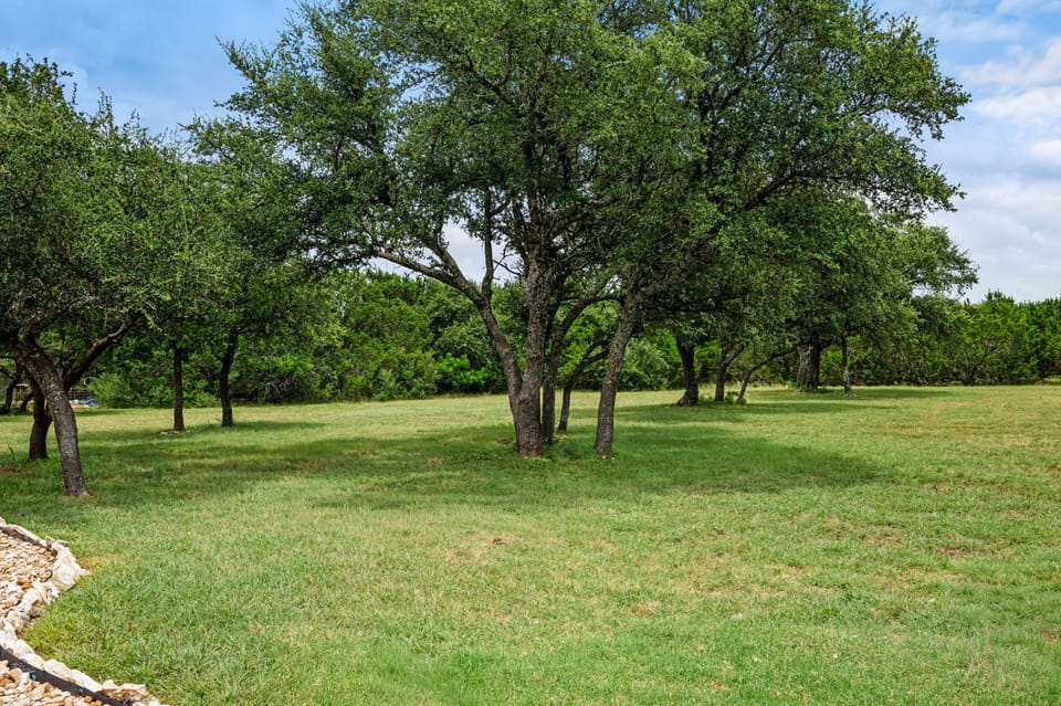 Stretch out and unwind in a large, beautifully maintained backyard with mature shade trees—perfect for morning coffee, outdoor games, or relaxing under the Texas sky.