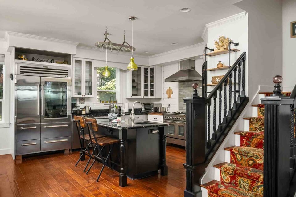 Warm hardwood floors connecting a stylish kitchen to the upper level.