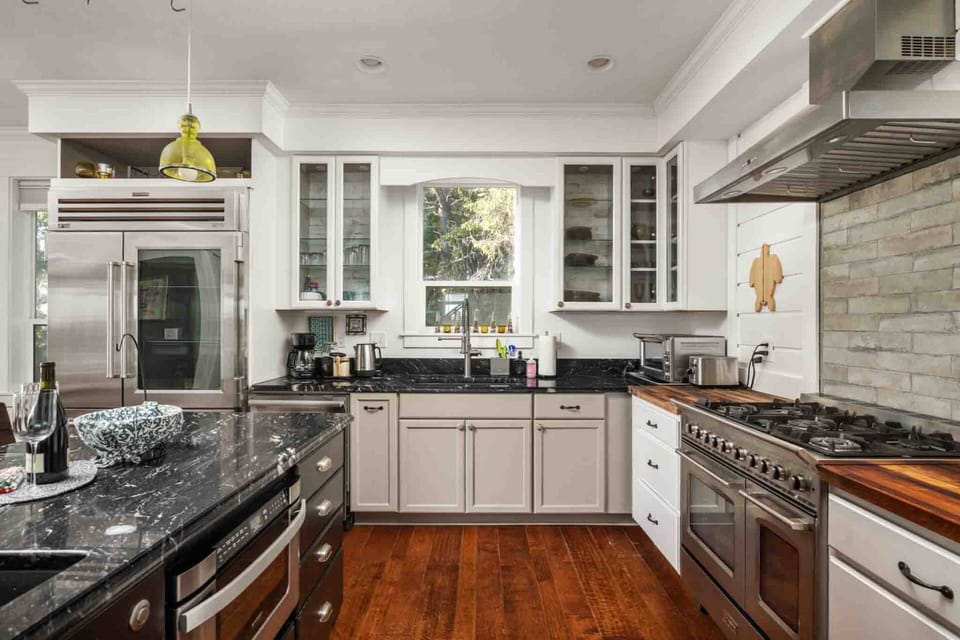 Spacious chef’s setup featuring high-end ranges and elegant dark stone counters.