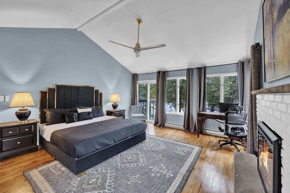 Main bedroom retreat with fireplace, workspace, and lake views.
