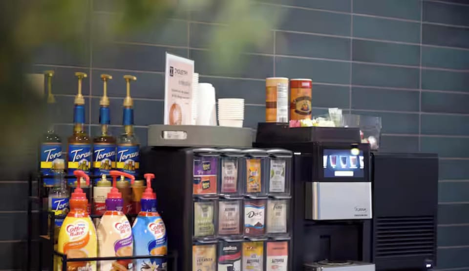 Complimentary coffee & tea station with syrups, creamers, and hot drink options