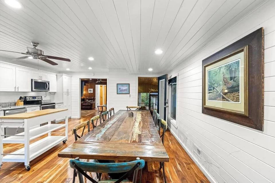 Gather around the rustic farmhouse table where mornings begin with coffee and laughter, and evenings linger over shared meals. The open layout connects you to the bright kitchen while natural light pours in from every angle.