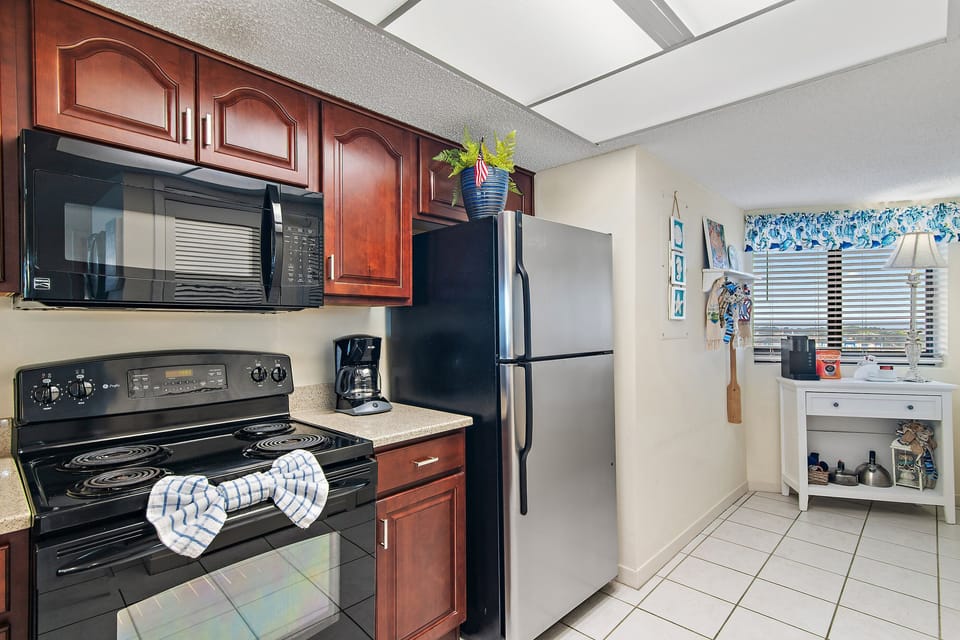 Fully equipped kitchen with full-size refrigerator, stove, microwave, and coffee maker