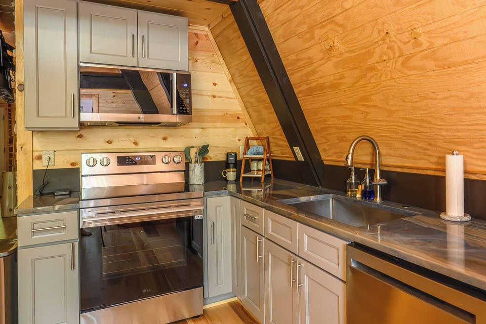 Your fully equipped kitchen features modern appliances and ample counter space beneath warm wood vaulted ceilings, creating an inviting space to prepare meals during your stay.