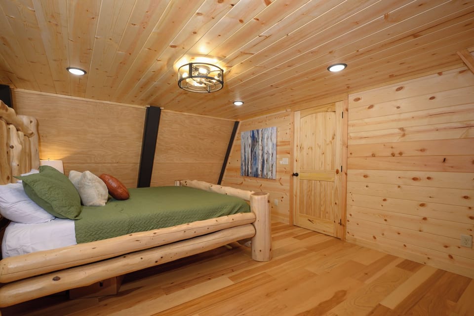 Drift off in your cozy cabin bedroom surrounded by warm wood tones and natural timber details. The handcrafted log bed invites peaceful mountain slumber.