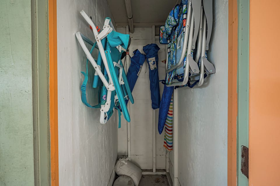 A convenient storage closet stocked with beach chairs, umbrellas, and outdoor gear to enhance your seaside adventures and sunny days by the water.