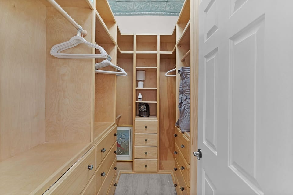 Your walk-in closet offers ample storage with custom shelving, hanging space, and built-in drawers, keeping your wardrobe organized and easily accessible throughout your stay.