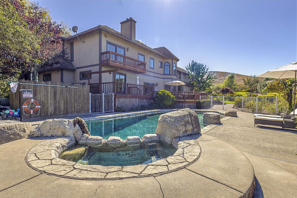 Private pool and stone spa with sunny resort-style backyard views