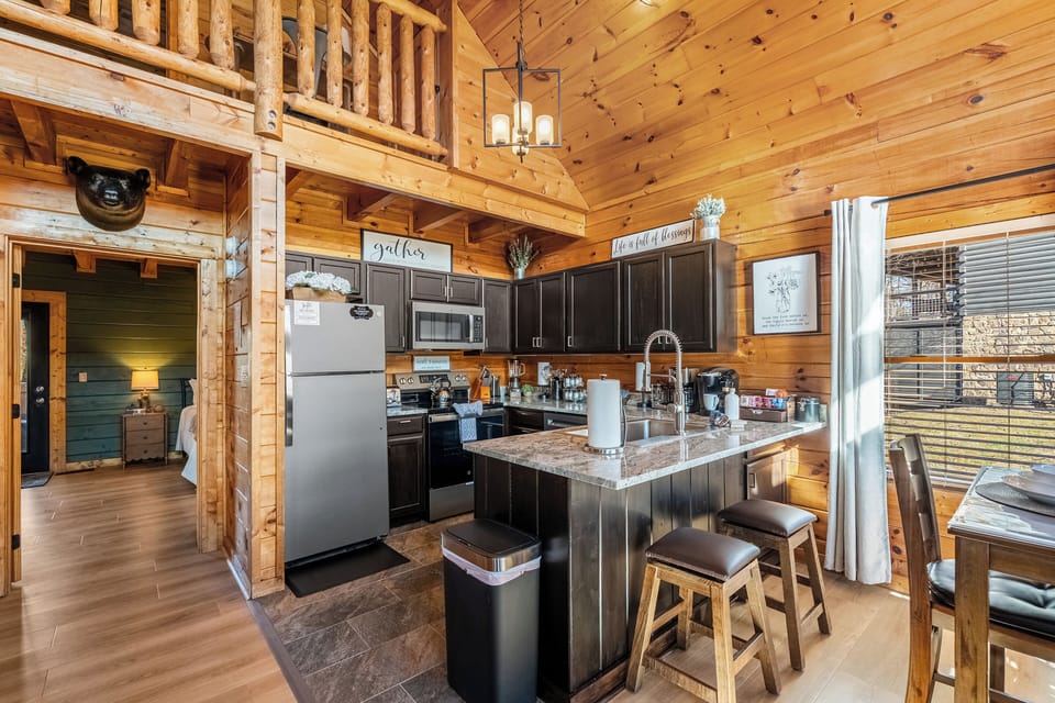 Rustic cabin kitchen with lofted ceilings, island seating, and warm wood charm