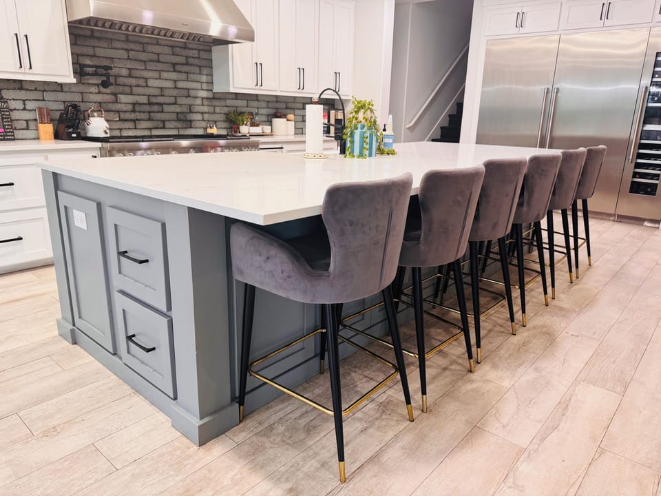 Massive quartz island with apron sink, dishwasher, outlets & storage.