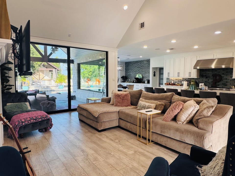 Sun-drenched living space featuring massive glass sliding doors w/pool views.